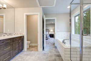 Luxurious bathroom with marble flooring, wooden cabinetry, and a walk-in shower